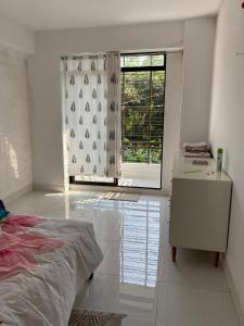 una camera da letto bianca con un letto e una finestra di Homestay in Chittagong, Raufabad Residential Area a Chittagong
