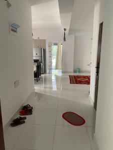 un soggiorno con pavimento bianco e tappeto rosso di Homestay in Chittagong, Raufabad Residential Area a Chittagong