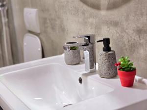 a bathroom sink with two soap dispensers on it at Siart Apartment in Tirana +26 photos