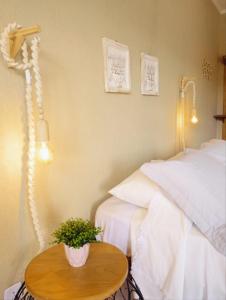 a bedroom with a bed and a table with a plant at Pousada Luz do Sol in Carrancas