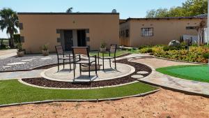 a patio with chairs and a table in front of a building at Kebo events agro &self catering apartments in Mochudi