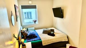 a small room with a bed and a window at Oslo VIBE in Oslo
