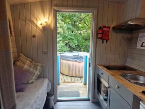 a small kitchen with a door leading to a yard at Glan yr Afon Dau - Relax Recuperate Hot Tub in Welshpool