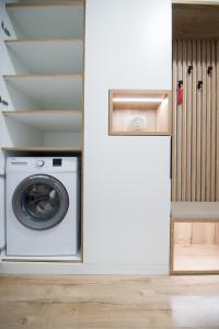 a washer and dryer in a laundry room with a door at Apartmán Dominanta in Liptovský Mikuláš