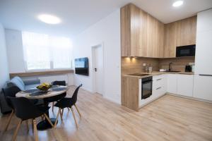 a kitchen and dining room with a table and chairs at Apartmán Dominanta in Liptovský Mikuláš