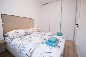 an unmade bed with two blue towels on it at Apartmán Dominanta in Liptovský Mikuláš