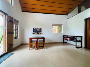 Una sala de estar con una mesa y un televisor. en Senthamarai villa, en Sultan Bathery 29 fotos más