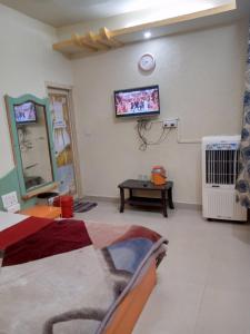 a bedroom with a bed and a tv on the wall at Hotel Amar palace pachmarhi in Pachmarhī