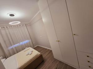 a small bedroom with a bed and a cabinet at Nea Apartment in Tirana