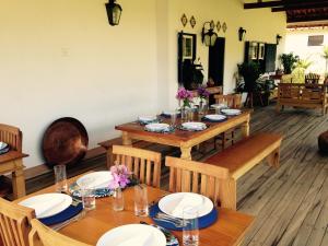 Un comedor con mesas y sillas de madera. en Pousada do Café - Chalé 3 - São Sebastião da Grama, en São Sebastião da Grama