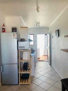 una cucina con frigorifero e pavimento piastrellato di At Sea, Melkbosstrand a Melkbosstrand Altre 6 foto