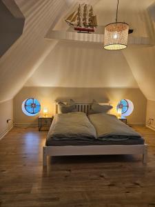 a bedroom with a large bed with two windows at Föhrzeit - Wohnung 4 Besonderes Apartment mit Garten in Borgsum