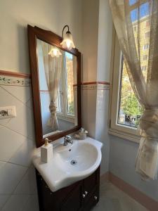 a bathroom with a sink and a mirror and a window at Maison Trionfale a 2 passi dal Vaticano in Rome