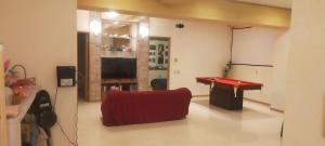 a room with a ping pong table and a red table at プルメリア,ｼﾞｬｸﾞｼﾞｰ,ﾌﾟﾛｼﾞｪｸﾀｰ,BBQ台,ﾐﾆﾋﾞﾘﾔｰﾄﾞ,広65平米,wii,wifi,P1有 in Tunugusuku