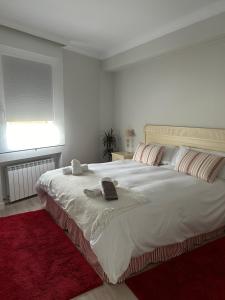 a bedroom with a large white bed with a red rug at Urdaibai Luxy in Pedernales