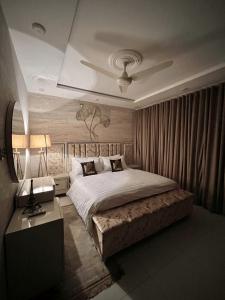 a bedroom with a large bed and a table at Kings Den 1BHK in Rawalpindi