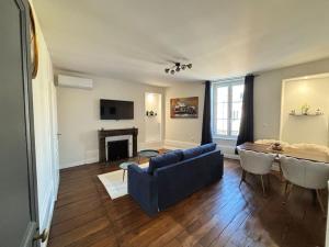 a living room with a blue couch and a table at Appartement 5 Climatisé confort moderne dans un t2 chaleureux in Limoges