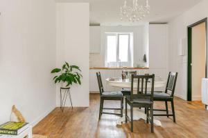 a kitchen and dining room with a table and chairs at La Boulangerie Appartement 1 in Janzé