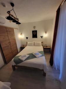 a bedroom with a large bed with two towels on it at Gizli Bahçe Pansiyon in Seferihisar +6 photos