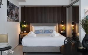 埃拉特Luxury Apartments And Studios At Sea Side By Rently的卧室里有一张白色的大床和一张桌子 更多37张照片