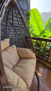 d'une chaise en osier avec un oreiller sur le balcon. dans l'établissement Casa Rural Tía Rita La Gomera, à Vallehermoso