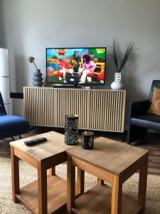 ein Wohnzimmer mit Fernseher und Couchtisch in der Unterkunft Appartement De Vrijbuiter, Resort Amelander Kaap in Hollum