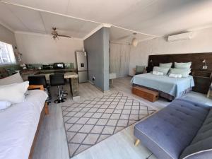 a hotel room with a bed and a couch at Emmaus Apartment in Bloemfontein