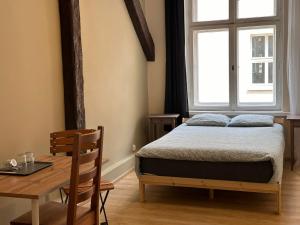 Un dormitorio con una cama y una mesa y una ventana. en Apollo 56, en Poznan