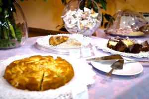 a table with plates of pastries and cakes on them at Hotel Villa Flora in Bogliasco