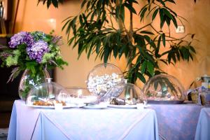 two tables with plates and vases with flowers on them at Hotel Villa Flora in Bogliasco +18 photos