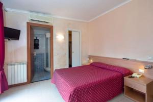 a bedroom with a bed with a red comforter at Hotel Villa Flora in Bogliasco