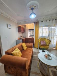 a living room with a couch and a table at Happy Holidays studios meublés à Yaoundé Nkozoa non loin du stade Olembé in Yaoundé
