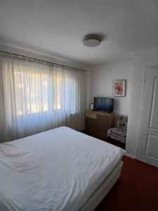 a bedroom with a white bed and a window at Apartmani Zaara in Sarajevo +55 photos