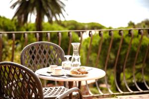 a table with a plate of food and a glass vase at Hotel Villa Flora in Bogliasco