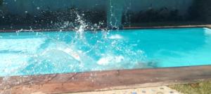 a person in a swimming pool with water splashing at Casa analia in Porto Seguro