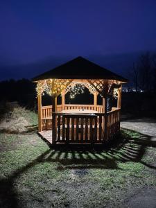 un cenador con luces encendidas en un patio en Wiejska Chata w Doline Baryczy, en Ujeździec Mały
