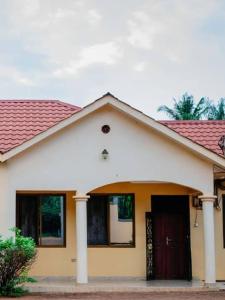 een wit huis met een rood dak bij Cozy home in Morogoro in Morogoro