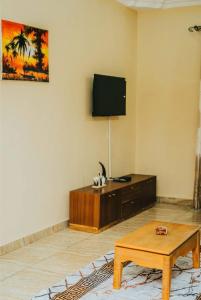 een woonkamer met een salontafel en een flatscreen-tv bij Cozy home in Morogoro in Morogoro