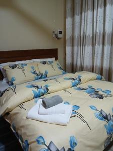 twee bedden in een slaapkamer met handdoeken erop bij Cozy home in Morogoro in Morogoro