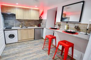 a kitchen with a counter and two red stools at L'Arena - Love Room, Jacuzzi in La Seyne-sur-Mer