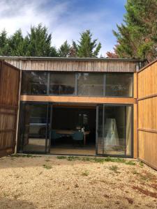 una casa di legno con porte in vetro e un tavolo di Lagreze a Montagnac-sur-Lède