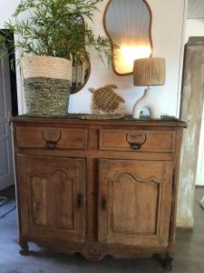 una cassettiera di legno con una lampada e due piante sopra di Lagreze a Montagnac-sur-Lède