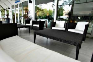 a room with chairs and a table and windows at Hotel Marebello in Rimini