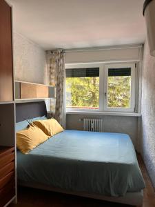 a bedroom with a bed and two windows at Central recently renovated apartment - Casa Tre Pini in Madonna di Campiglio