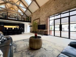 una sala de estar con un sofá y una mesa en Church Barn House, Wadworth, en Wadworth