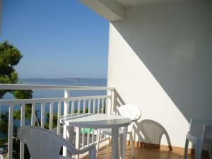 una mesa y sillas en un balcón con vistas al océano en Villa Maja original since 2005, en Baška Voda