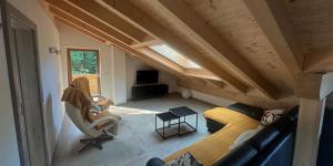 a room with a couch and chairs in a attic at Alpenchalets Zugspitze in Grainau