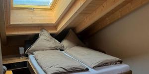 a bed in a room with a wooden ceiling at Alpenchalets Zugspitze in Grainau