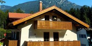 a house with a balcony with a mountain in the background at Alpenchalets Zugspitze in Grainau