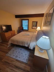um quarto com uma cama e uma mesa com um abajur em Gateway Condominium em Mendon